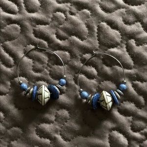Silver hoop earrings in shades of blue and beige.